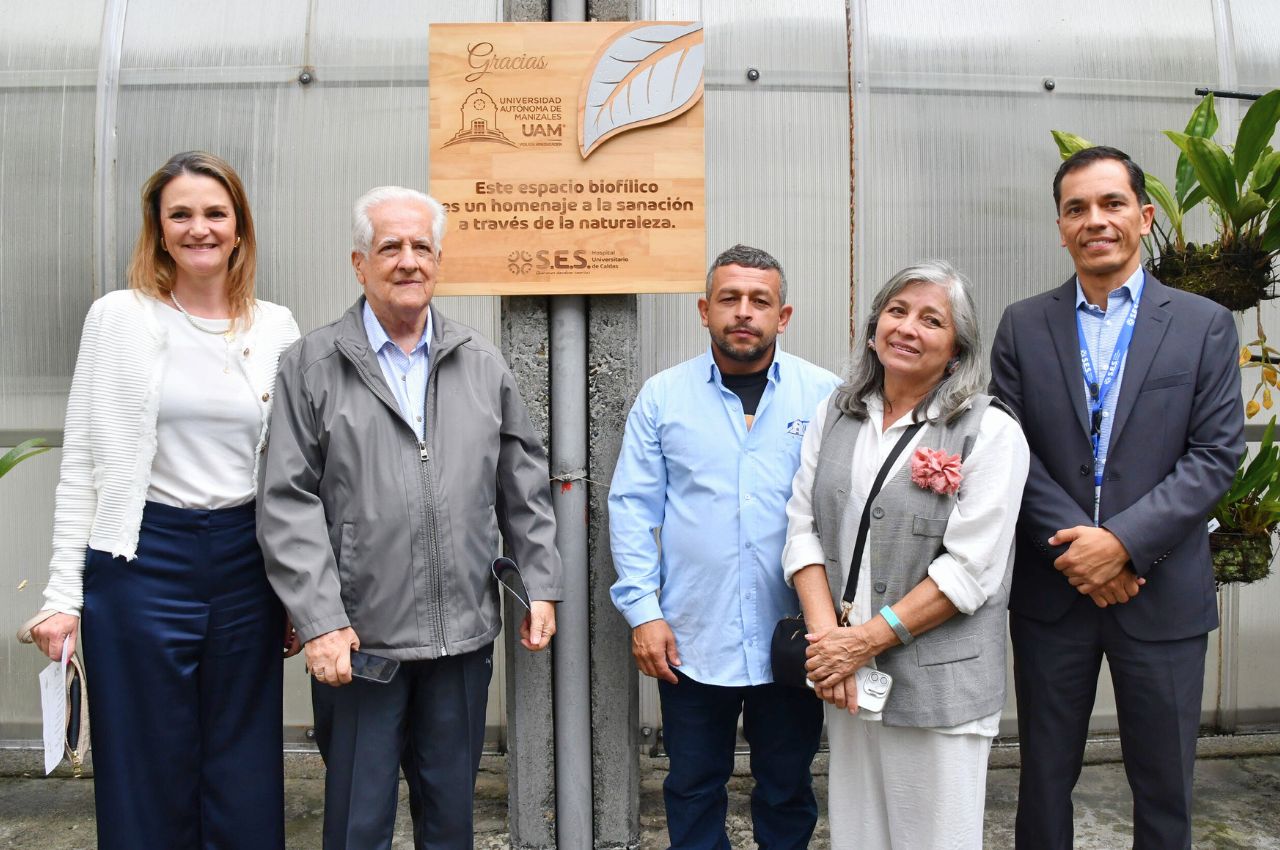 Representantes de la UAM con el gerente del Hospital de Caldas posando con la placa conmemorativa.