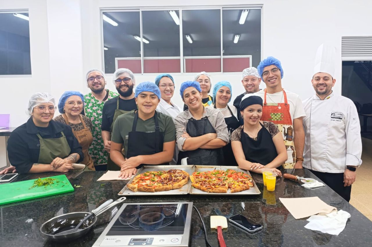 Un grupo de trabajadores con sus pizzas hechas en los talleres de cocina en la UAM